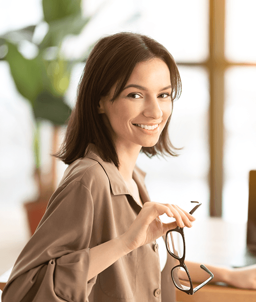 A female with glasses in her hand has a good smile